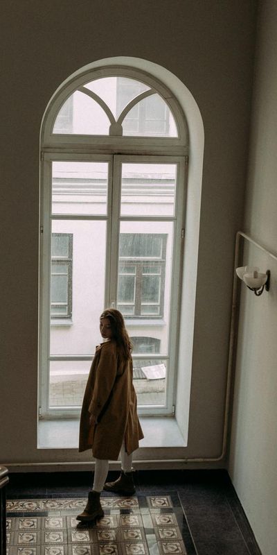 Silhouette of a person in a balancing pose against a window.